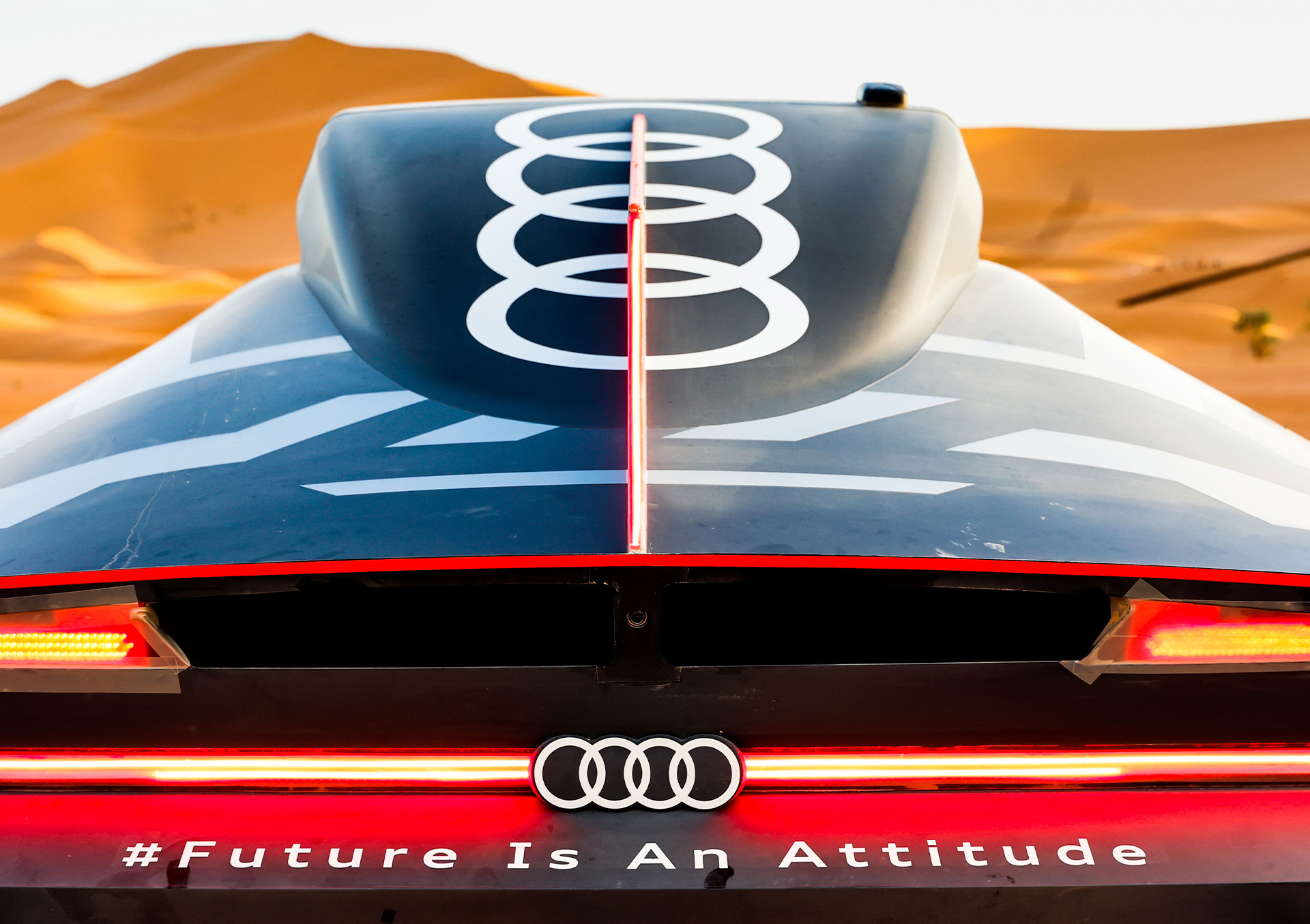 Blick in eine Wüstenlandschaft über das Heck des Audi RS Q e-tron hinweg.